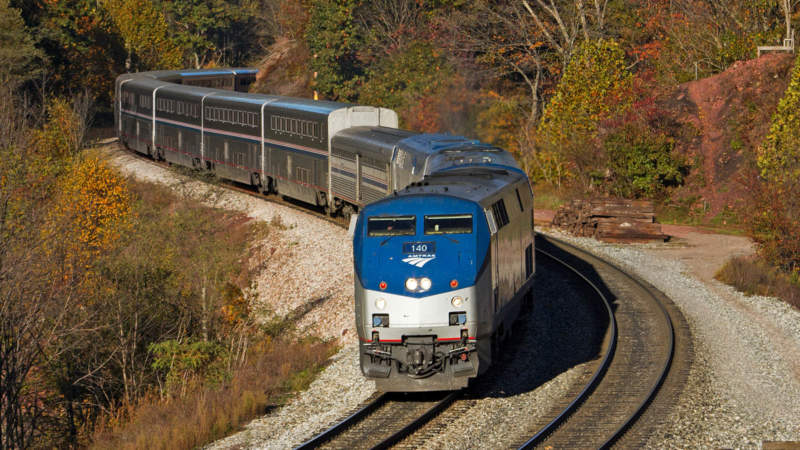 Amtrak train passing fall leaves