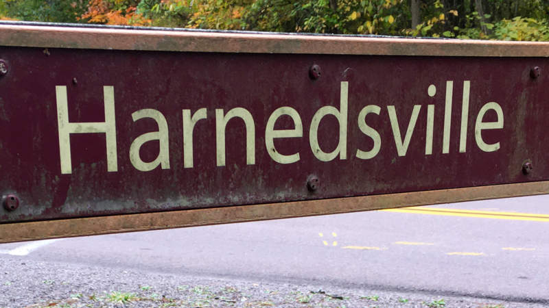Harnedsville sign on fence